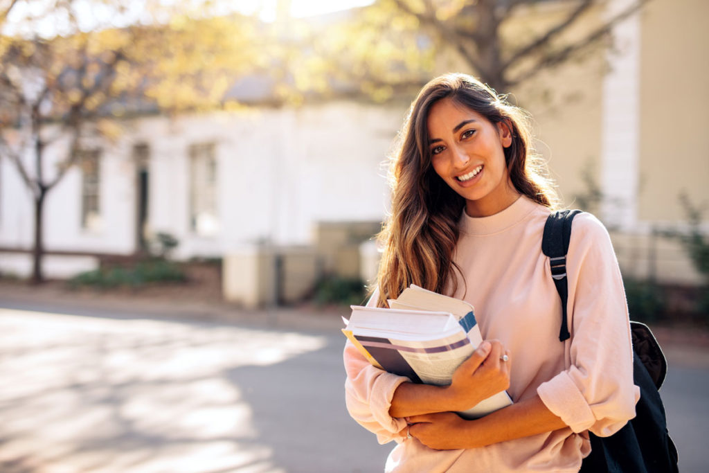 College student holding books on campus