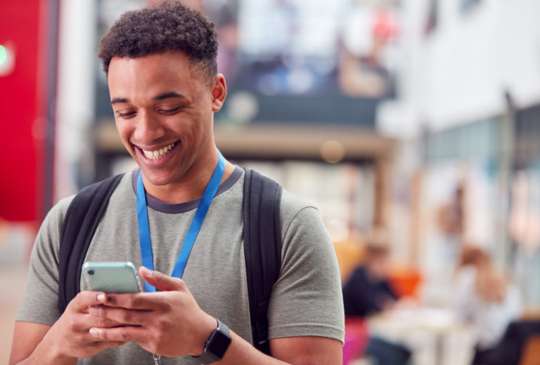 College student on phone smiling