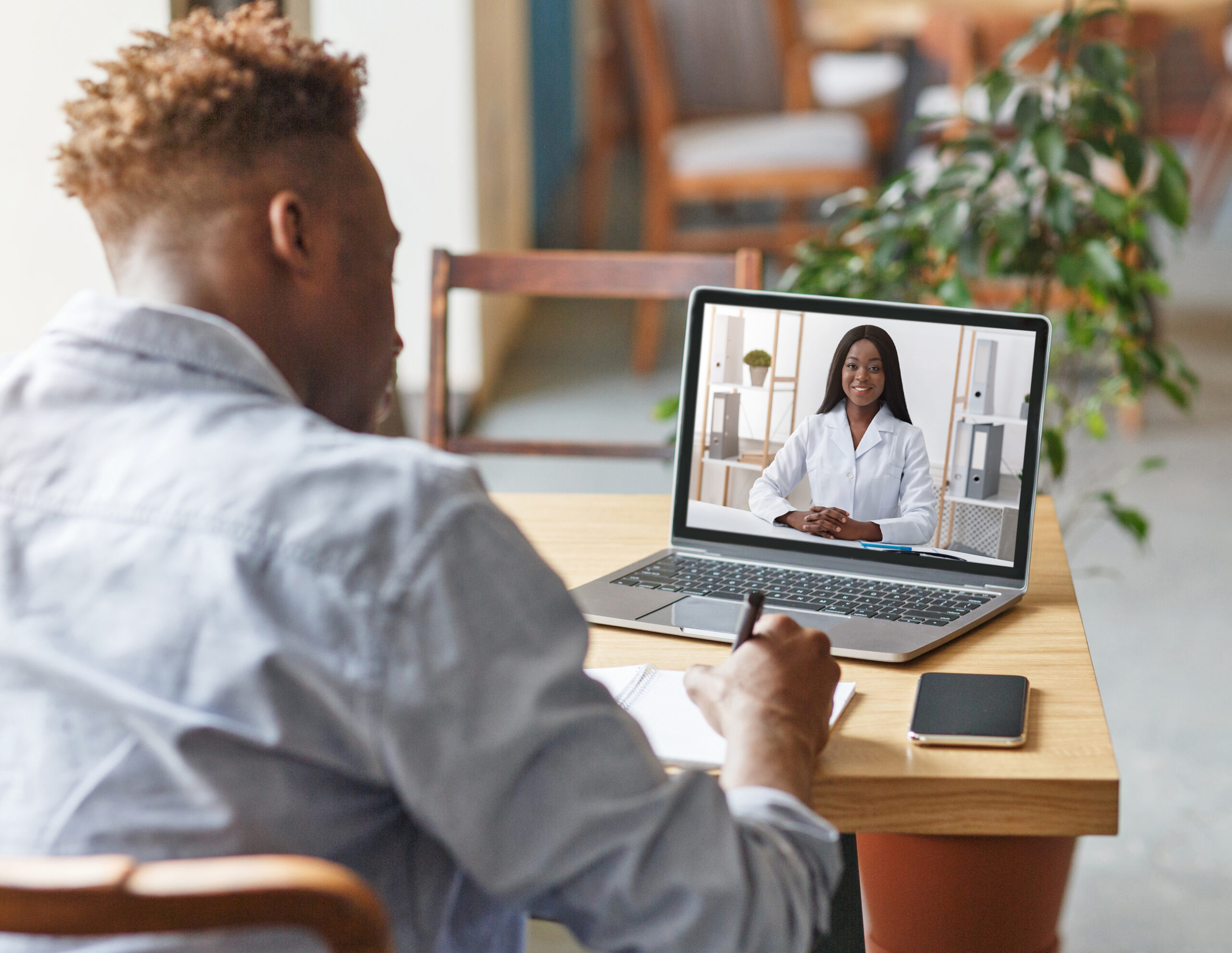 Student in telehealth appointment on computer - doctor appears on screen