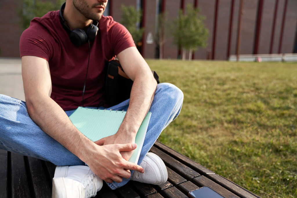 College student sitting on campus bench