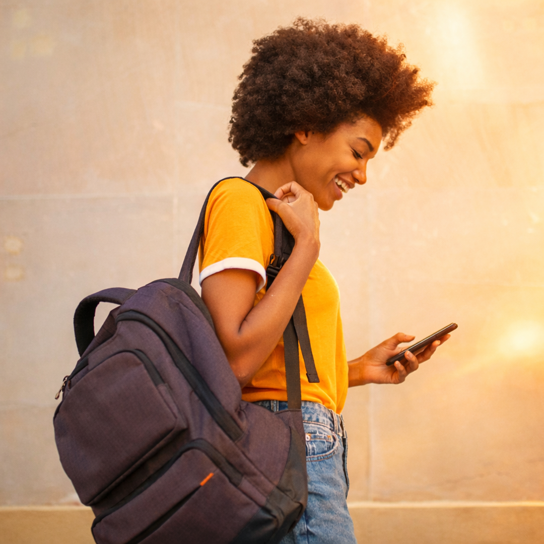 Student with backpack looking down at phone