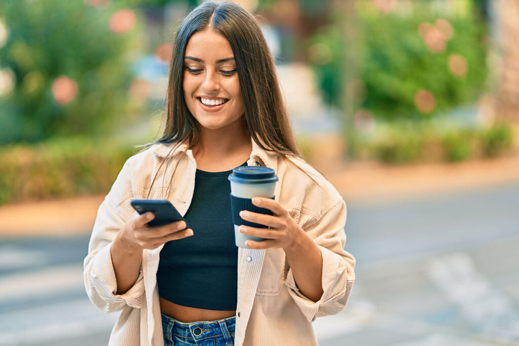 College student with coffee and phone on campus