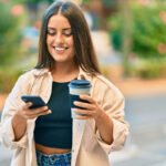 College student with coffee and phone on campus