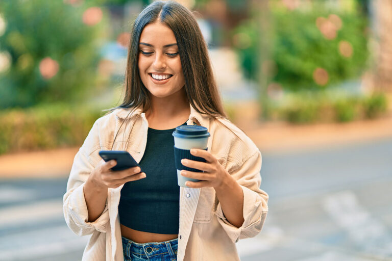 College student with coffee and phone on campus