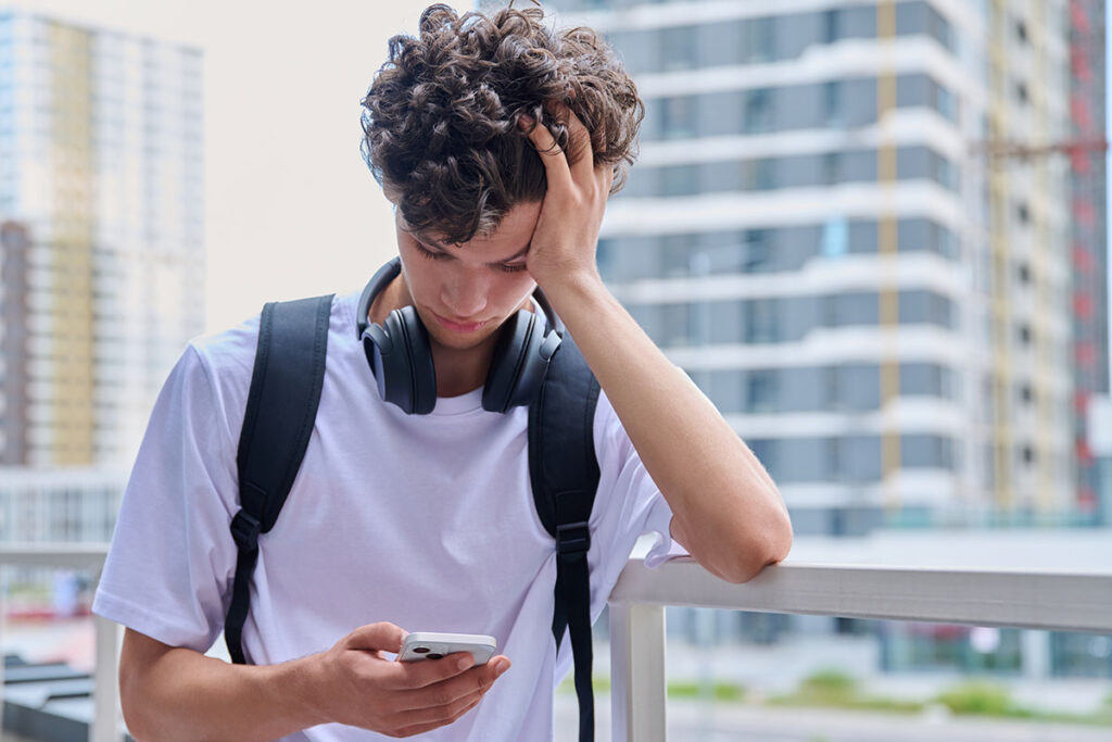 College student looking down at phone