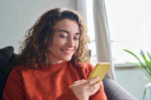 College student looking at phone in room