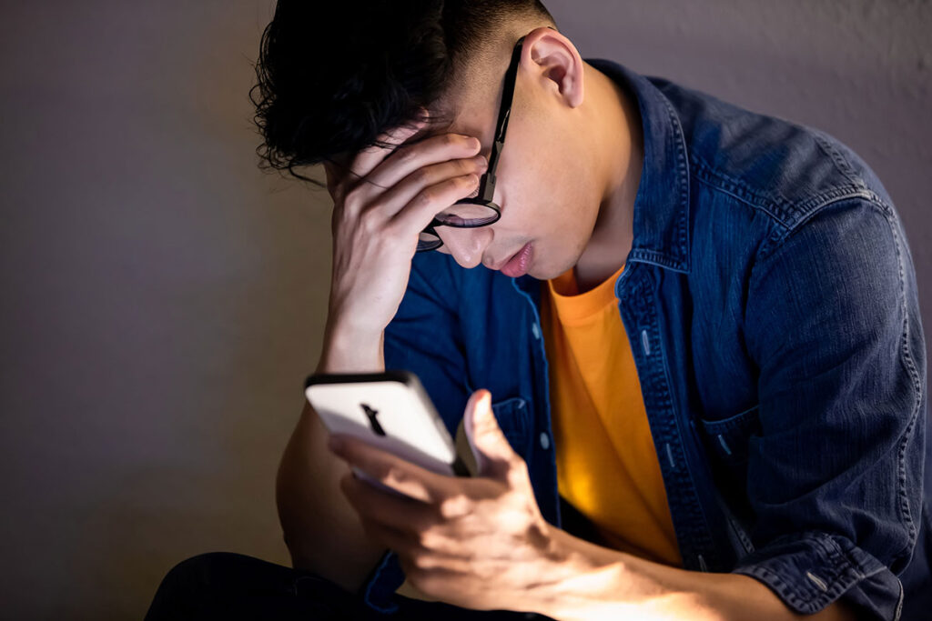 Stressed college student looking at phone