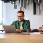 Confident,Handsome,Programmer,In,Eyeglasses,Developing,Software,Over,Laptop,At