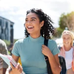 A group of gen z students walking outside on a college campus.