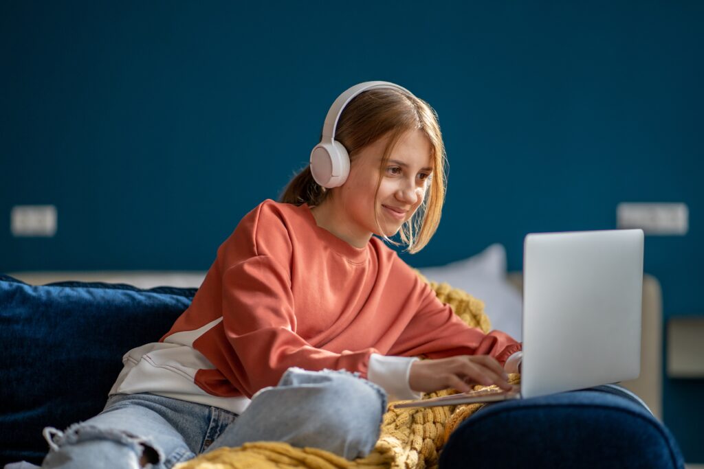 Child working on laptop with headphones on