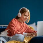 Child working on laptop with headphones on