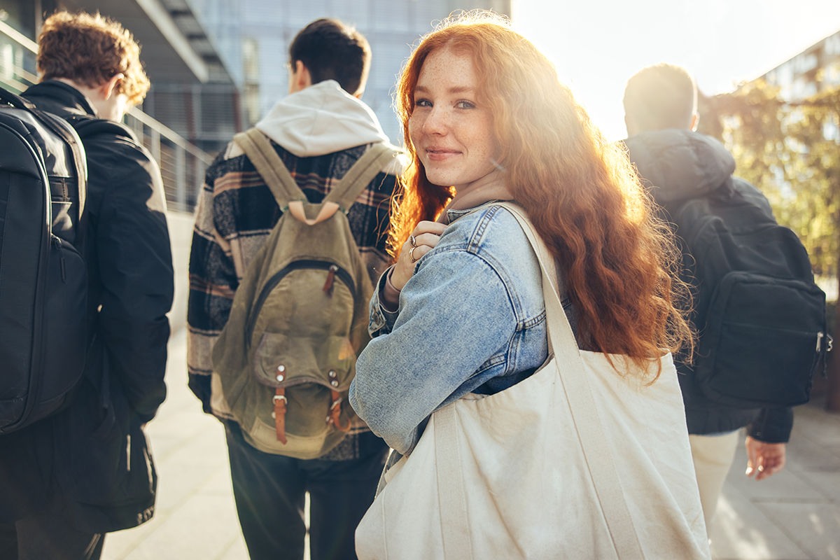 Student with backpack looking backward