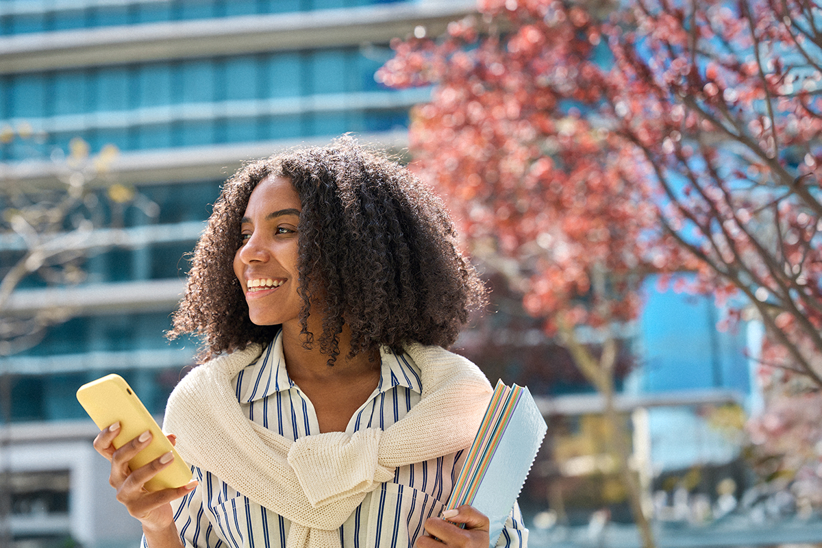 Student outside on campus with phone